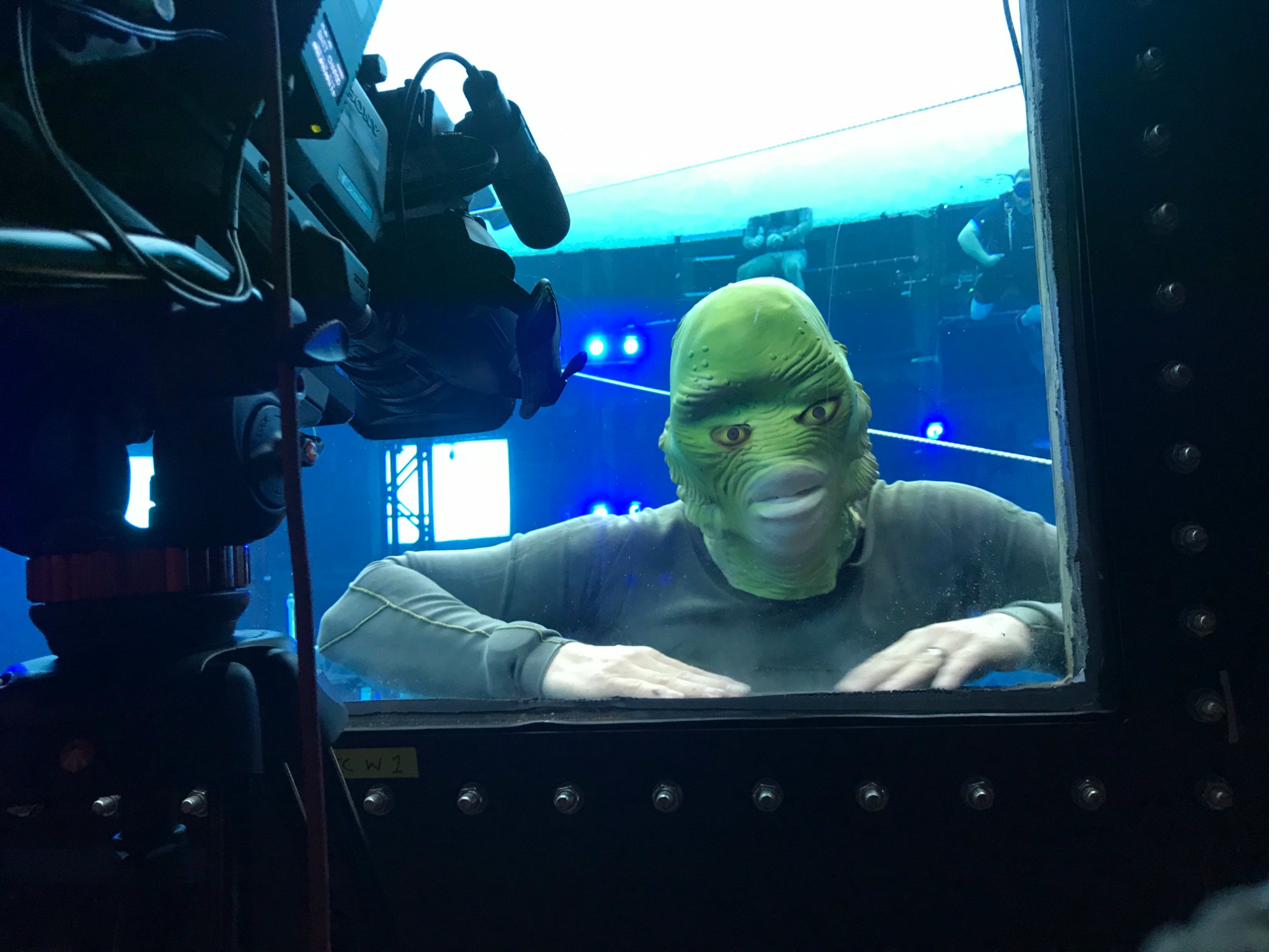 Someone wearing a Creature from the Black Lagoon mask in the tank viewing window