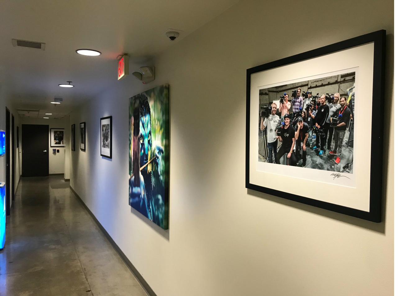 A crew photo framed on the wall in Cameron's office hallway, next to Avatar artwork