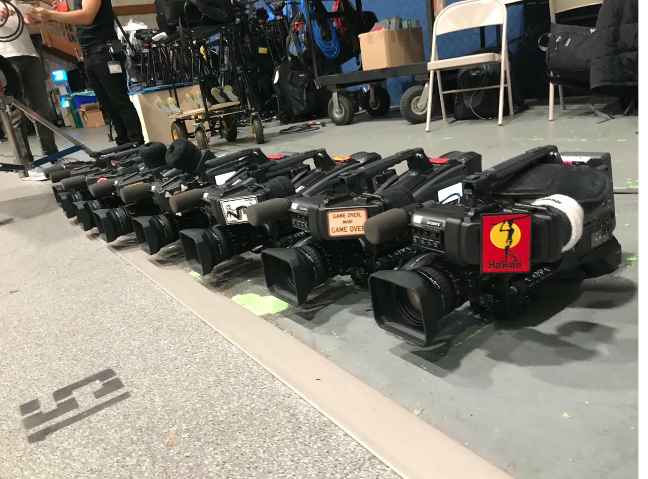 A row of Sony broadcast cameras lined up on the soundstage, each personalized with patches