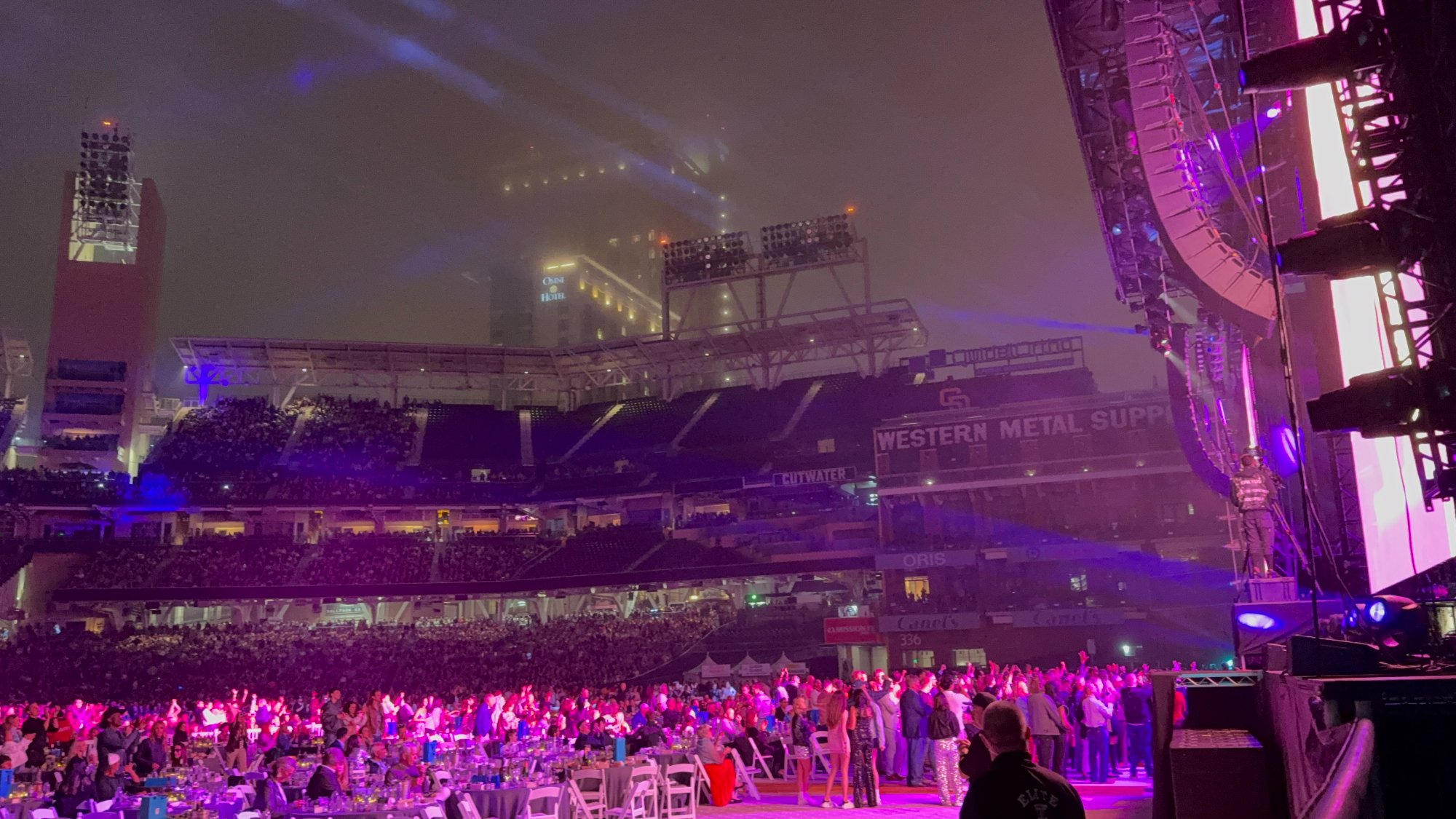 The crowd at Petco Park during Elton John's concert — purple and pink stage lighting washing over thousands
