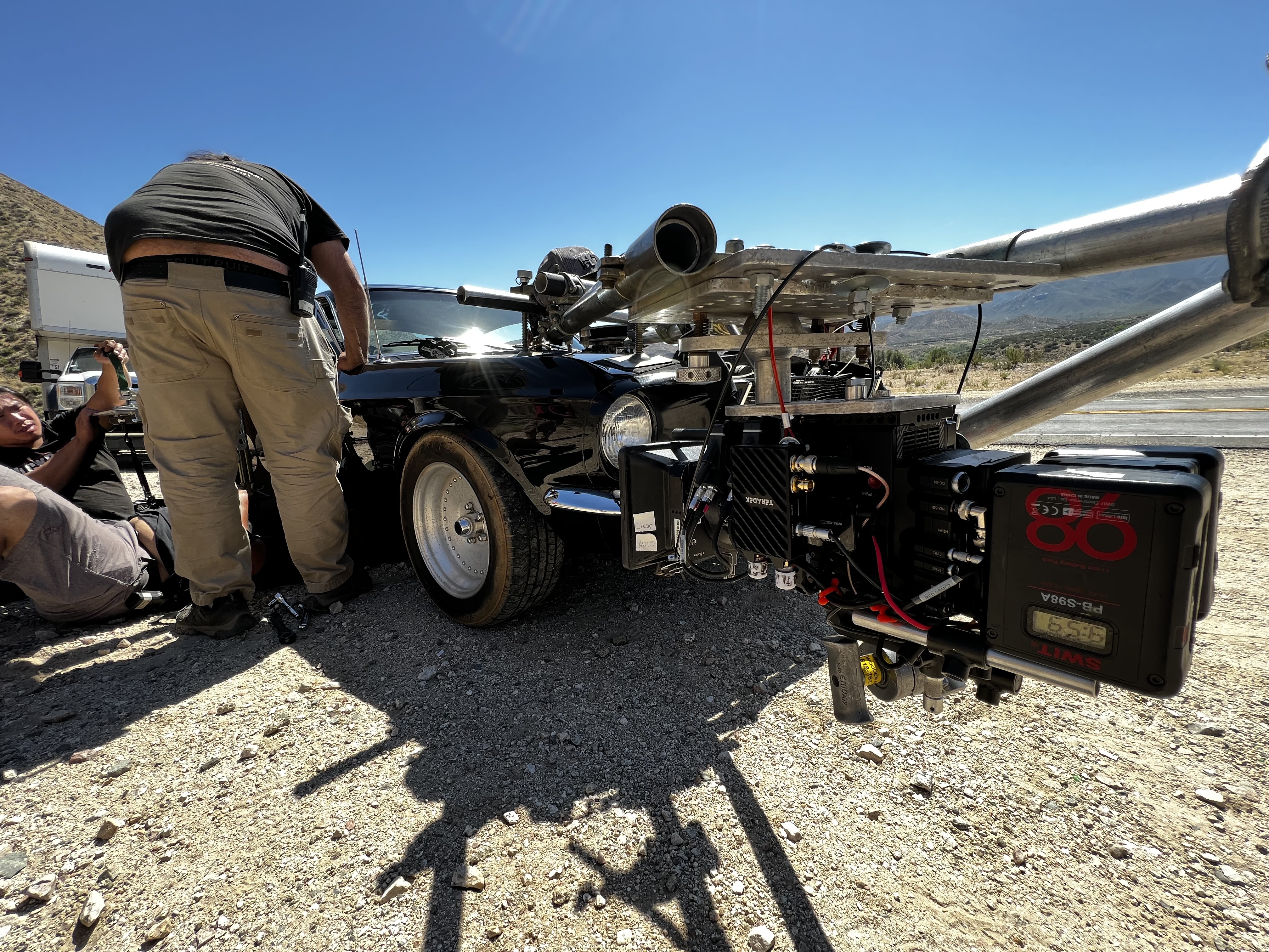 Car rig from the side — camera mounted to the vehicle with the desert landscape behind