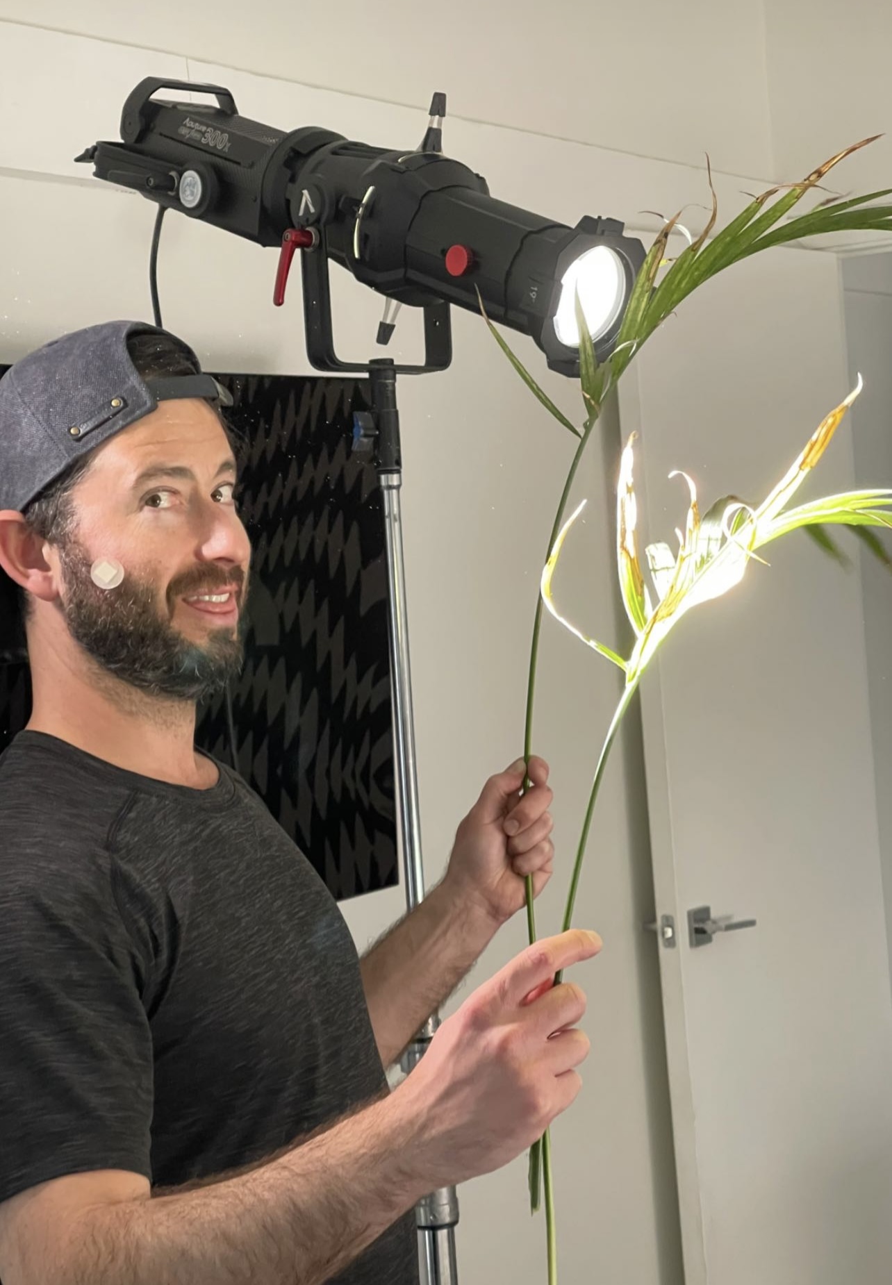 Shane Stanger holding a palm frond in front of an Aputure light to create breathing light effect